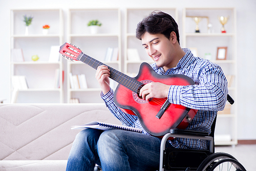 Disabled man playing guitar at home