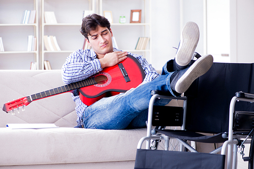 Disabled man playing guitar at home