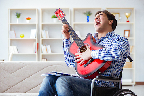 Disabled man playing guitar at home