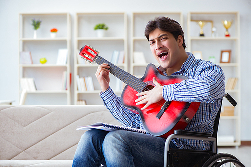 Disabled man playing guitar at home