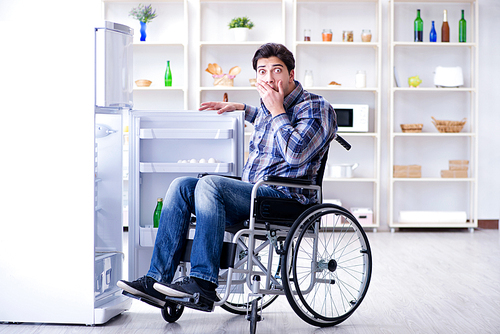 Young disabled injured man opening the fridge door