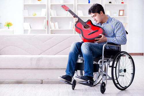 Disabled man playing guitar at home