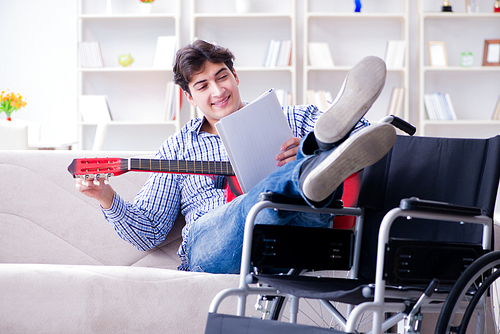 Disabled man playing guitar at home