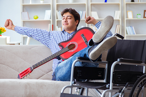 Disabled man playing guitar at home