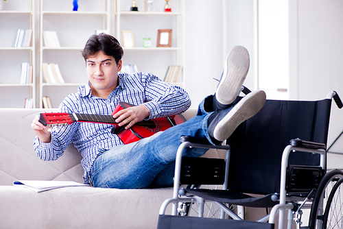 Disabled man playing guitar at home