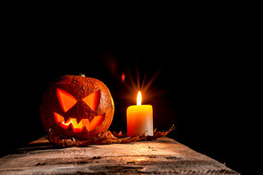 Halloween pumpkin and candle on black background