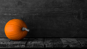 One orange pumpkin on dark wooden background, Halloween concept