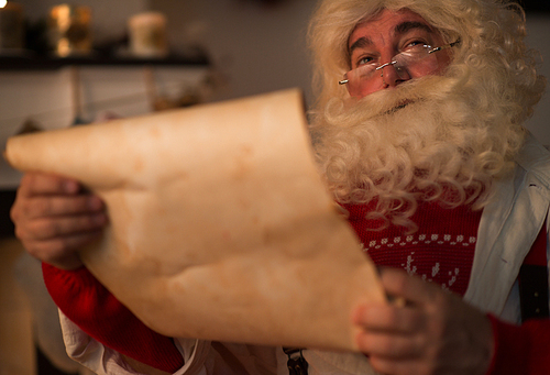 Santa Claus at Home holding old paper scroll