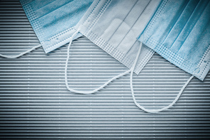Medical disposable sterile masks on striped background top view.