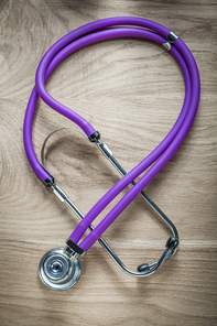 Stethoscope on wooden board vertical view.