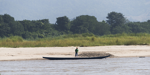 Man standing on shoreline of River Mekong, Lai Ngao, Wiang Kaen District, Chiang Rai Province, Thailand