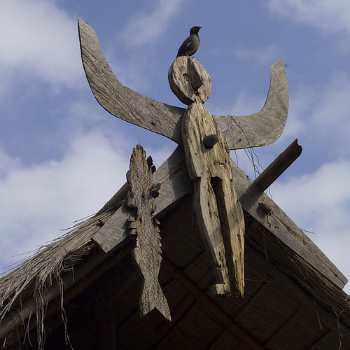 Low angle view of bird perching on sculpture, Chiang Rai, Thailand