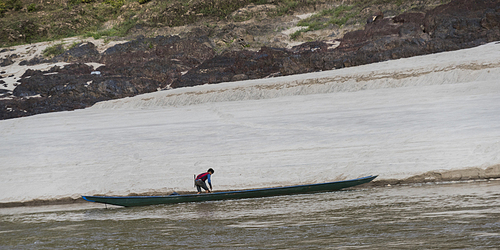 Person along side a row boat in River Mekong, Laos