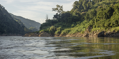 Scenic view of river shoreline with mountain range in background, River Mekong, Sainyabuli Province, Laos