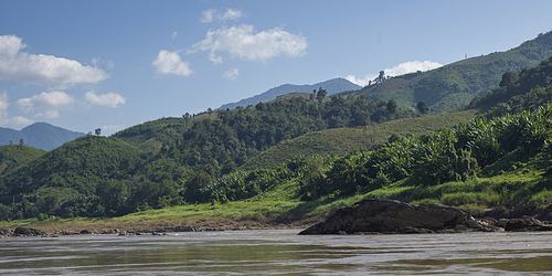 Scenic view of river shoreline with mountain range in background, River Mekong, Sainyabuli Province, Laos