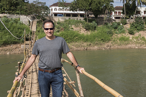 Man standing on bamboo bridge, Nam Khan river, Luang Prabang, Laos