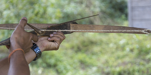 Person hand aiming with crossbow, Luang Prabang, Laos
