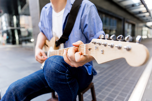 Portrait of young musician with guitar in city