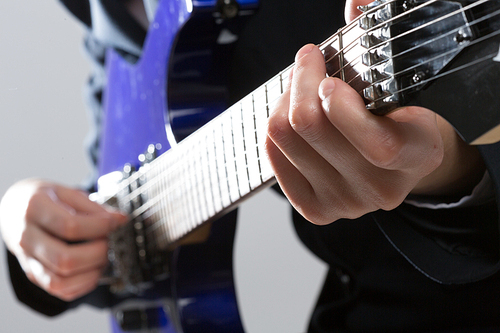 Close up of male hands playing electric guitar
