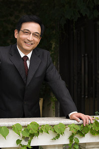 Smiling businessman leaning on a ledge