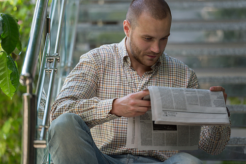 Handsome man reading a newspaper and thinking