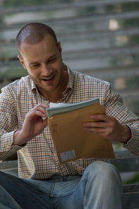 Portrait of a businessman received envelope reading documents