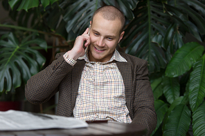 Young businessman at phone at green office