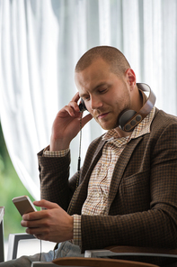 Business man resting at cafe and listening music using vintage headphones