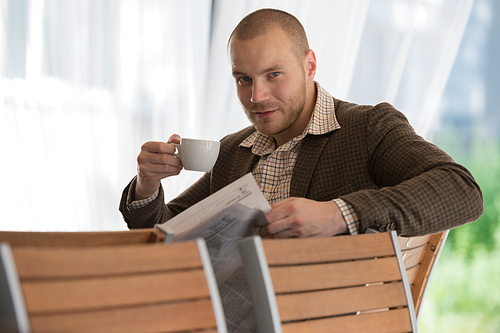 Pensive businessman reading a newspaper in cafe