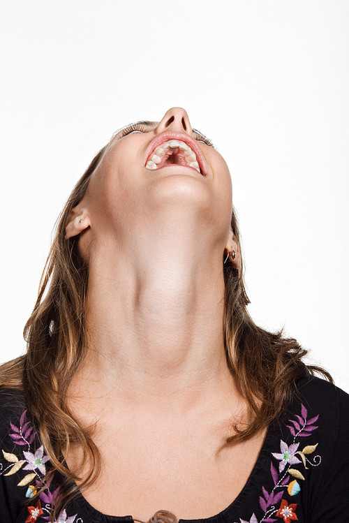 Portrait of young woman with her head back laughing