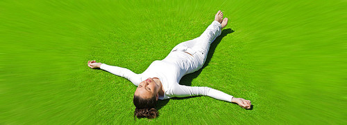 Young girl dressed in white lying on the grass