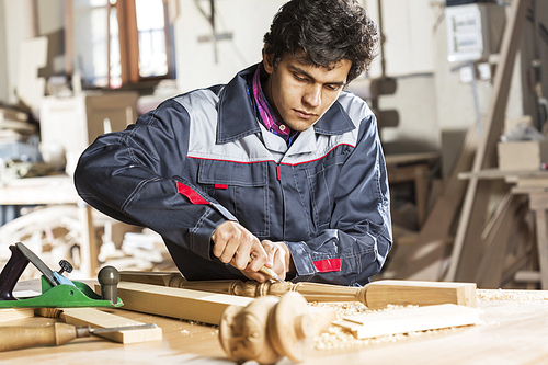 Young carpenter working with cutter in his studio