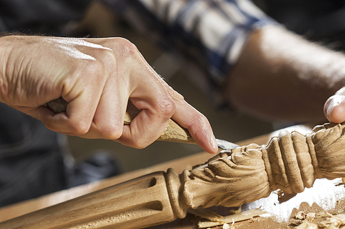 Close up of carpenter's hands working with cutter in his studio