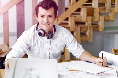 Young businessman working in office with headphones