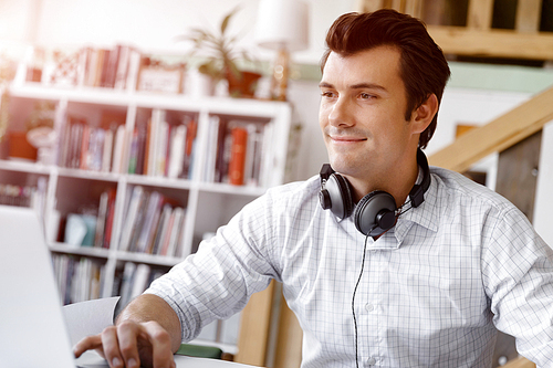 Young businessman working in office with headphones