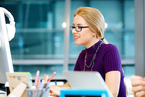 Young and pretty business woman working in office