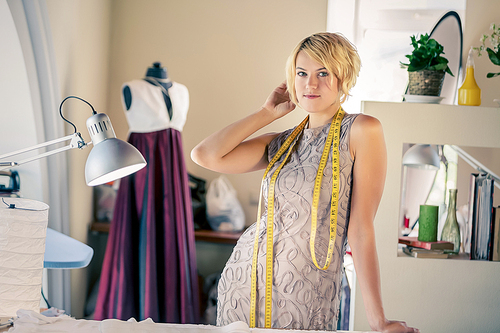 Young woman dressmaker at tailors making measures