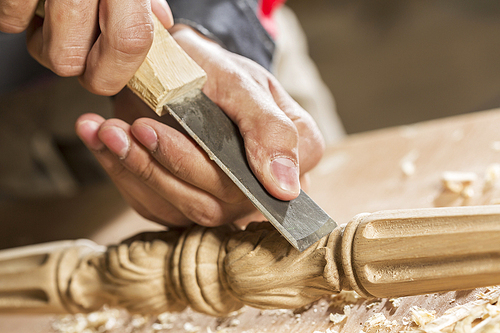 Close up of carpenter's hands working with cutter in his studio