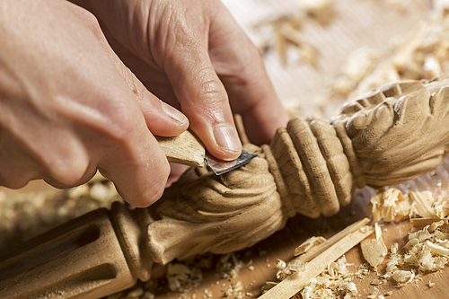 Close up of carpenter's hands working with cutter in his studio