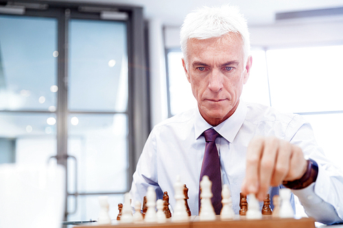 Businessman in office playing chess
