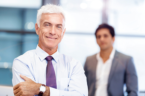 Businessman standing in office smiling at camera
