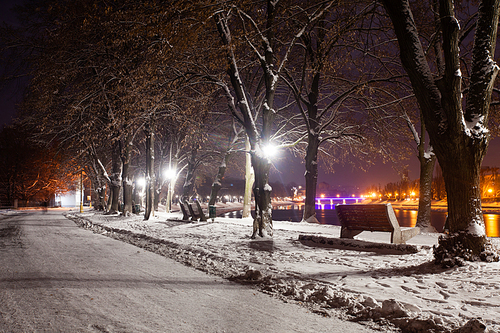 Snow-covered embankment in evening city. Beautiful winter landscape