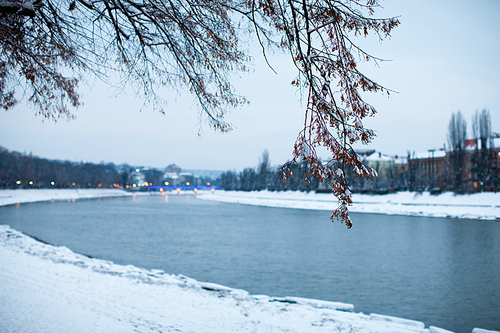 Snow-covered embankment in evening city. Beautiful winter landscape