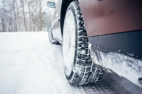 Car with winter tire on snowy road, defocused image