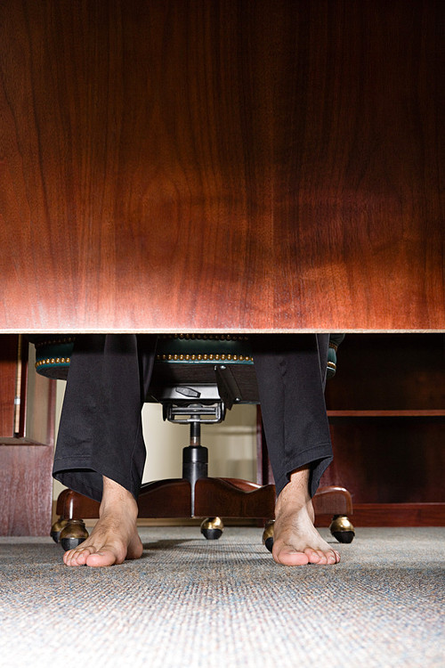 Feet of businessman under desk
