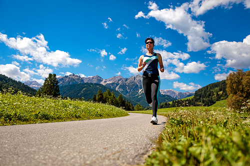 Woman jogging outdoors. Italy Dolomites Alps