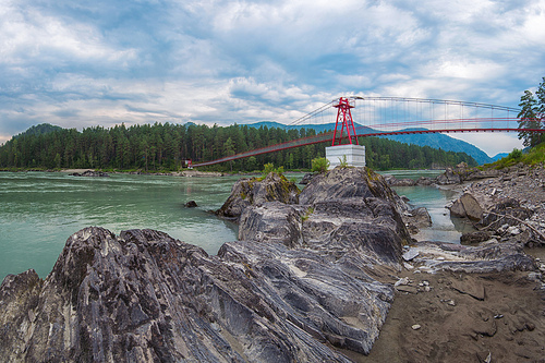 suspension bridge on mountain river Katun in Altai