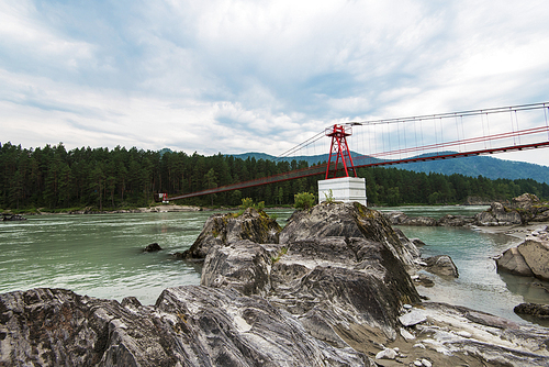 suspension bridge on mountain river Katun in Altai