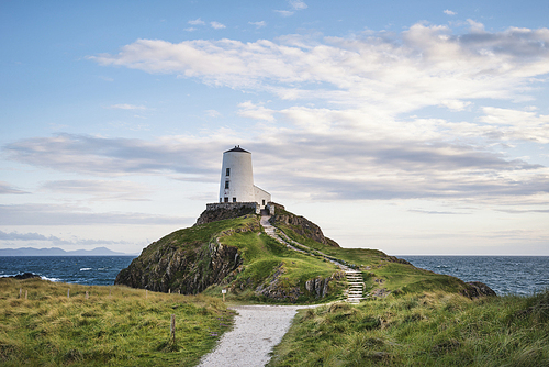 Beautiful Summer landscape image of lighthouse on end of headland with beautiful sky
