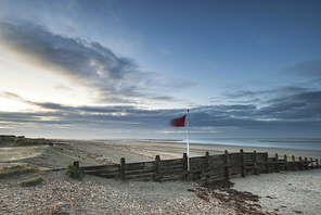 Beautiful beach coastal landscape image at sunrise with colorful vibrant sky